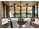 Bright dining area features a built-in bench, a modern chandelier, and black frame windows overlooking the backyard at 4864 E Lafayette Blvd, Phoenix, AZ 85018