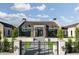 A modern home with a symmetrical facade, an iron gate, stone accents, and a well-manicured lawn at 4864 E Lafayette Blvd, Phoenix, AZ 85018