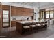 Spacious kitchen with wood cabinets, marble backsplash, an island with bar stool seating, and modern lighting fixtures at 4864 E Lafayette Blvd, Phoenix, AZ 85018