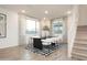 Bright dining room features a modern table, comfortable seating, large windows and staircase at 4920 W Walatowa St, Laveen, AZ 85339