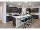 Stylish kitchen with a breakfast bar, dark wood cabinetry, and bright white countertops at 4920 W Walatowa St, Laveen, AZ 85339