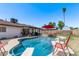 Backyard oasis featuring a sparkling pool, diving board, red umbrella and lounge chairs for ultimate relaxation at 5226 W Redfield Rd, Glendale, AZ 85306