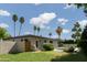 Charming home featuring a backyard with a refreshing pool, lush lawn, and swaying palm trees at 5341 E Sheena Dr, Scottsdale, AZ 85254
