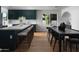 Beautiful kitchen featuring a large island, green cabinets, and a dining area with a black dining table and chairs at 5341 E Sheena Dr, Scottsdale, AZ 85254