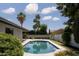 Inviting backyard pool surrounded by lush greenery and towering palm trees under a sunny sky at 5341 E Sheena Dr, Scottsdale, AZ 85254