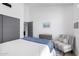 Bright bedroom features white bedding, an accent chair, and closet with sliding doors at 5401 N 25Th St, Phoenix, AZ 85016