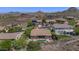 Aerial view of a home with a private pool and patio, surrounded by lush desert landscaping and scenic mountain views at 6133 W Fetlock Ter, Phoenix, AZ 85083
