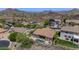 Aerial view showcases a home with a pristine pool and spa nestled in a desert landscape with breathtaking mountain views at 6133 W Fetlock Ter, Phoenix, AZ 85083