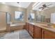Bright bathroom featuring a tub, glass block windows, and double vanity at 6133 W Fetlock Ter, Phoenix, AZ 85083