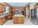 Well-equipped kitchen featuring an island, wood cabinetry, and modern appliances at 6133 W Fetlock Ter, Phoenix, AZ 85083