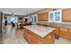 Open kitchen with island, wood cabinets, and view to the dining and living area at 6133 W Fetlock Ter, Phoenix, AZ 85083