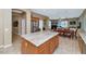 Open kitchen featuring island, wood cabinetry, and view into other living spaces at 6133 W Fetlock Ter, Phoenix, AZ 85083