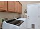Laundry room featuring modern washer and dryer, and wooden cabinets at 6133 W Fetlock Ter, Phoenix, AZ 85083