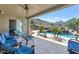 Covered patio with comfortable seating offers stunning views of the pool and desert landscape, perfect for outdoor living at 6133 W Fetlock Ter, Phoenix, AZ 85083