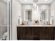 Modern bathroom with dual sinks, LED mirrors, dark wood cabinets, and stone countertop at 6525 E Cave Creek Rd # 40, Cave Creek, AZ 85331