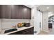 Kitchenette with dark wood cabinets, marble countertops, sink, microwave, and sliding barn door at 6525 E Cave Creek Rd # 40, Cave Creek, AZ 85331