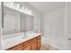 Well-lit bathroom showcasing a single sink vanity, a large mirror, and a tub with shower at 664 E Windsor Dr, Gilbert, AZ 85296