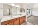 Bathroom featuring double sinks, spacious countertops, framed mirrors, and bright natural light at 664 E Windsor Dr, Gilbert, AZ 85296