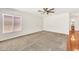 Bright, carpeted bedroom with a ceiling fan and large window offers ample natural light at 664 E Windsor Dr, Gilbert, AZ 85296