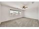 Bedroom featuring neutral carpet, a ceiling fan, and a large window providing natural light at 664 E Windsor Dr, Gilbert, AZ 85296