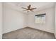 Bedroom with a ceiling fan, neutral carpet, and window allowing natural light at 664 E Windsor Dr, Gilbert, AZ 85296