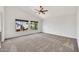 Bright bedroom with neutral carpet, ceiling fan, and large windows at 664 E Windsor Dr, Gilbert, AZ 85296