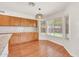 A kitchen with hardwood floors, wooden cabinets, granite countertops, and ample natural light from the window at 664 E Windsor Dr, Gilbert, AZ 85296
