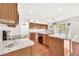 Modern kitchen featuring stainless appliances, granite counters, wooden cabinetry, and hardwood flooring at 664 E Windsor Dr, Gilbert, AZ 85296