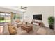 Bright living room with a ceiling fan, neutral palette, and sliding glass door access to yard at 664 E Windsor Dr, Gilbert, AZ 85296