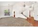 Spacious living room featuring tall ceilings, modern chandeliers, hardwood floors, and staircase to the second floor at 664 E Windsor Dr, Gilbert, AZ 85296