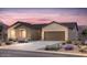 Charming single-story home featuring a two-car garage, neutral-toned exterior, desert landscaping, and a concrete driveway at 6694 W Ripken Ct, Florence, AZ 85132