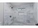 Close up of shower with marbled tile walls, a shower niche, and a window at 676 W Shawnee Dr, Chandler, AZ 85225