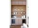 Stylish built-in bar area with wine refrigerators, custom lighting, and open shelving at 7215 N Black Rock Trl, Paradise Valley, AZ 85253