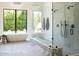Bright bathroom with a freestanding tub, glass-enclosed shower, and marble bench at 7215 N Black Rock Trl, Paradise Valley, AZ 85253