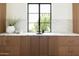 Custom wood cabinets featuring marble counters and a window with green views at 7215 N Black Rock Trl, Paradise Valley, AZ 85253