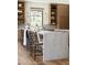 Stylish kitchen with a marble island with seating, custom cabinets and open shelving at 7215 N Black Rock Trl, Paradise Valley, AZ 85253