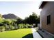 Expansive landscaped yard with lush green lawn, stone pathway, and modern design elements at 7215 N Black Rock Trl, Paradise Valley, AZ 85253