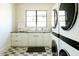 Bright laundry room featuring modern appliances, shaker cabinets, and checkered floors at 7215 N Black Rock Trl, Paradise Valley, AZ 85253