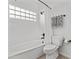 Bright bathroom features a tub with shower, white tile, and modern fixtures at 7536 W Sequoia Dr, Glendale, AZ 85308