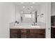 Bathroom vanity with brown cabinetry, granite countertop and large mirror at 7536 W Sequoia Dr, Glendale, AZ 85308
