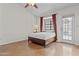 Minimalist bedroom features a cozy bed, accent window treatments, and door access at 7536 W Sequoia Dr, Glendale, AZ 85308