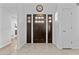 Welcoming foyer featuring a stylish front door with sidelights and a decorative wall clock at 7536 W Sequoia Dr, Glendale, AZ 85308