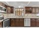 Updated kitchen with stainless steel appliances, granite countertops, and dark wood cabinets at 7536 W Sequoia Dr, Glendale, AZ 85308
