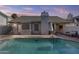 A serene swimming pool in a private backyard with a covered patio and desert landscaping at 7536 W Sequoia Dr, Glendale, AZ 85308