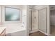 Bright bathroom featuring soaking tub, open glass shower and light color palette at 7716 W Pueblo Ave, Phoenix, AZ 85043