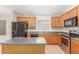 Open kitchen features wood cabinets, center island, and black appliances at 7716 W Pueblo Ave, Phoenix, AZ 85043