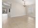 Expansive living room with neutral tile flooring, arched doorway, chandelier, and sliding glass doors to the backyard at 7716 W Pueblo Ave, Phoenix, AZ 85043