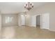 Bright and airy living room showcasing tile floors, a chandelier, and multiple doorways offering seamless transitions at 7716 W Pueblo Ave, Phoenix, AZ 85043