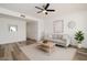 Bright living room features modern ceiling fan, neutral paint and decor, plus wood-look flooring at 7801 N 44Th Dr # 1003, Glendale, AZ 85301