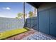 Enclosed patio featuring a small patch of artificial grass, brick accents, and a secure gate at 7801 N 44Th Dr # 1003, Glendale, AZ 85301